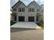 Traditional townhome exterior in neutral tones featuring two garage doors and covered entrances at 3136-A Brownstone Se Ln, Atlanta, GA 30354