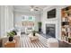 Cozy living room with a fireplace, ceiling fan, large windows, and modern furniture at 3136-A Brownstone Se Ln, Atlanta, GA 30354