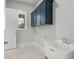 Laundry room with utility sink, shaker cabinets, and tile floor at 170 Ewing Way, Dacula, GA 30019