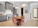 Modern kitchen with gray cabinets, stainless steel appliances, quartz countertops, and adjacent dining area with pink chairs at 10871 Serenbe Ln, Chattahoochee Hills, GA 30268