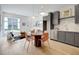 Open-concept living space with kitchen, dining area, and comfortable seating arrangement with large windows and hardwood floors at 10871 Serenbe Ln, Chattahoochee Hills, GA 30268