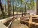 Backyard staircase leading to a wooded area, with a glimpse of the home's deck at 819 Bermuda Run, Woodstock, GA 30189