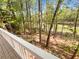Wooded backyard featuring staircase access and lake view beyond the trees at 819 Bermuda Run, Woodstock, GA 30189