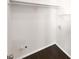 A compact laundry room with all-white walls and dark laminate floors at 819 Bermuda Run, Woodstock, GA 30189