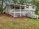 Charming home with a covered porch, white railing, and two-story design nestled among mature trees at 125 Enterprise Dr, Temple, GA 30179