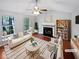 Bright living room with a fireplace, ceiling fan, and large windows overlooking the yard at 5723 Antelope Trl, Atlanta, GA 30349