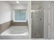 Bathroom featuring a bathtub, tiled wall and a glass door shower at 3513 Lakeview Crk, Lithonia, GA 30038