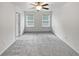 A bedroom with light grey carpet, two windows, ceiling fan and white paint at 3513 Lakeview Crk, Lithonia, GA 30038