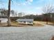 Charming single-story home featuring a gravel driveway and a well-maintained yard with mature trees at 118 Mann Blvd, Stockbridge, GA 30281