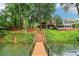 Beautiful backyard with a lake view and a wooden bridge leading to the house at 6219 Woodlake Dr, Buford, GA 30518