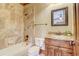 Bathroom features rustic wooden cabinets, marble countertops, tub and shower combination at 6219 Woodlake Dr, Buford, GA 30518