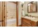 Bathroom featuring a custom vanity with granite countertop, decorative lighting, and a tiled shower/tub combo at 6219 Woodlake Dr, Buford, GA 30518