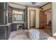 Luxurious bathroom featuring dark wood vanities, stone tile flooring, and a makeup vanity at 6219 Woodlake Dr, Buford, GA 30518