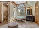 Beautiful bathroom featuring an arched window, a clawfoot tub, a glass enclosed shower, and a dark wood vanity at 6219 Woodlake Dr, Buford, GA 30518