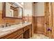 Bathroom with wood paneling, granite countertop vanity, mirror and bronze faucet at 6219 Woodlake Dr, Buford, GA 30518