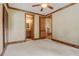 Bedroom with wood trim, plantation shutters, and rustic wooden door access to bathroom and hall at 6219 Woodlake Dr, Buford, GA 30518