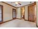 Bedroom with wood trim, plantation shutters, and rustic wooden door access to bathroom at 6219 Woodlake Dr, Buford, GA 30518