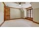 Bedroom with carpet, wood trim, shutters, wood door and decorative ceiling fan at 6219 Woodlake Dr, Buford, GA 30518