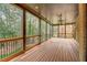 Covered patio featuring black railing, natural wood elements, and forest views at 6219 Woodlake Dr, Buford, GA 30518