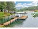 Beautiful deep-water lake view of a large dock featuring multiple boat slips and platforms for relaxation and enjoyment at 6219 Woodlake Dr, Buford, GA 30518