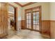 Elegant entryway featuring wood-paneled walls, beautiful hardwood floors, and glass-paneled doors leading to an outdoor deck at 6219 Woodlake Dr, Buford, GA 30518