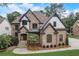 Stunning two-story home with stone and brick exterior, complemented by mature landscaping at 6219 Woodlake Dr, Buford, GA 30518