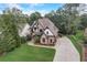 Aerial view of home showing the driveway, lawn, and exterior brick, stone, and siding at 6219 Woodlake Dr, Buford, GA 30518