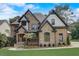 Beautiful two-story home with manicured lawn, stone and brick exterior at 6219 Woodlake Dr, Buford, GA 30518