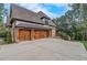 This three-car garage features wooden doors and stone pillars at 6219 Woodlake Dr, Buford, GA 30518