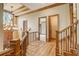 Hallway with hardwood floors, decorative lighting, and a staircase with metal railing at 6219 Woodlake Dr, Buford, GA 30518