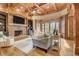 Cozy living room with stone fireplace, custom built-ins, and large windows showcasing the outdoor view at 6219 Woodlake Dr, Buford, GA 30518