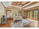Luxurious main bedroom with a tray ceiling, a ceiling fan, hardwood floors, and access to a balcony at 6219 Woodlake Dr, Buford, GA 30518