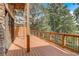 Outdoor patio with wood flooring, stone columns, and wooded views at 6219 Woodlake Dr, Buford, GA 30518