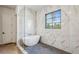 Bright bathroom featuring a modern tub, marble walls, a glass shower, and a black framed window at 225 River Valley Lot 5 Ct, Atlanta, GA 30328