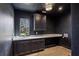Well-lit laundry room featuring dark walls, a built-in counter, and black cabinets for ample storage at 225 River Valley Lot 5 Ct, Atlanta, GA 30328