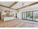 Open-concept living area featuring wooden beams, kitchen, black windows and access to the outdoor fireplace patio at 225 River Valley Lot 5 Ct, Atlanta, GA 30328