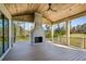 Covered outdoor patio with a stone fireplace and ceiling fan, offering views of the lush backyard at 225 River Valley Lot 5 Ct, Atlanta, GA 30328