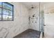 Walk-in shower with marble walls and bronze fixtures next to a bright, natural light filled window at 225 River Valley Lot 5 Ct, Atlanta, GA 30328