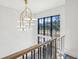 Bright staircase featuring a black framed window, white walls, and an ornate brass chandelier at 225 River Valley Lot 5 Ct, Atlanta, GA 30328