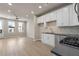 Open-concept view of kitchen and living space; white cabinets, stainless appliances, wood-look flooring, ceiling fan at 88 Black Gum Ln # 43, Auburn, GA 30011