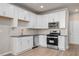 Modern kitchen featuring white cabinets, stainless steel appliances, gray counters and backsplash with luxury vinyl floors at 88 Black Gum Ln # 43, Auburn, GA 30011