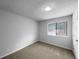 The carpeted bedroom has neutral paint, a window with a view to the driveway, and a door at 130 Ashley Oaks Dr, Mcdonough, GA 30253