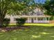 Inviting two-story house with a covered front porch, nestled on a green lawn with mature trees at 225 Woodfield Ct, Mcdonough, GA 30253