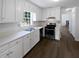 White kitchen with stainless steel appliances, including a gas range and laminate countertops at 225 Woodfield Ct, Mcdonough, GA 30253
