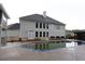 Back exterior view of house and pool featuring large windows and gray siding at 168 Harmony Grove Rd, Lilburn, GA 30047