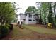 Back exterior view of house with backyard access and beautiful surrounding foliage at 168 Harmony Grove Rd, Lilburn, GA 30047