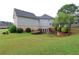 Backyard featuring a large grassy area, mature trees, and a partial view of the home's exterior at 168 Harmony Grove Rd, Lilburn, GA 30047