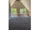 Attic bedroom featuring a vaulted ceiling, carpet floors and two windows at 168 Harmony Grove Rd, Lilburn, GA 30047