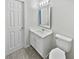 Bright bathroom features a white vanity, framed mirror, and neutral flooring at 2708 Parkway Trl, Lithonia, GA 30058