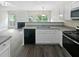 An open kitchen overlooking the fireplace with modern appliances and fixtures at 2708 Parkway Trl, Lithonia, GA 30058